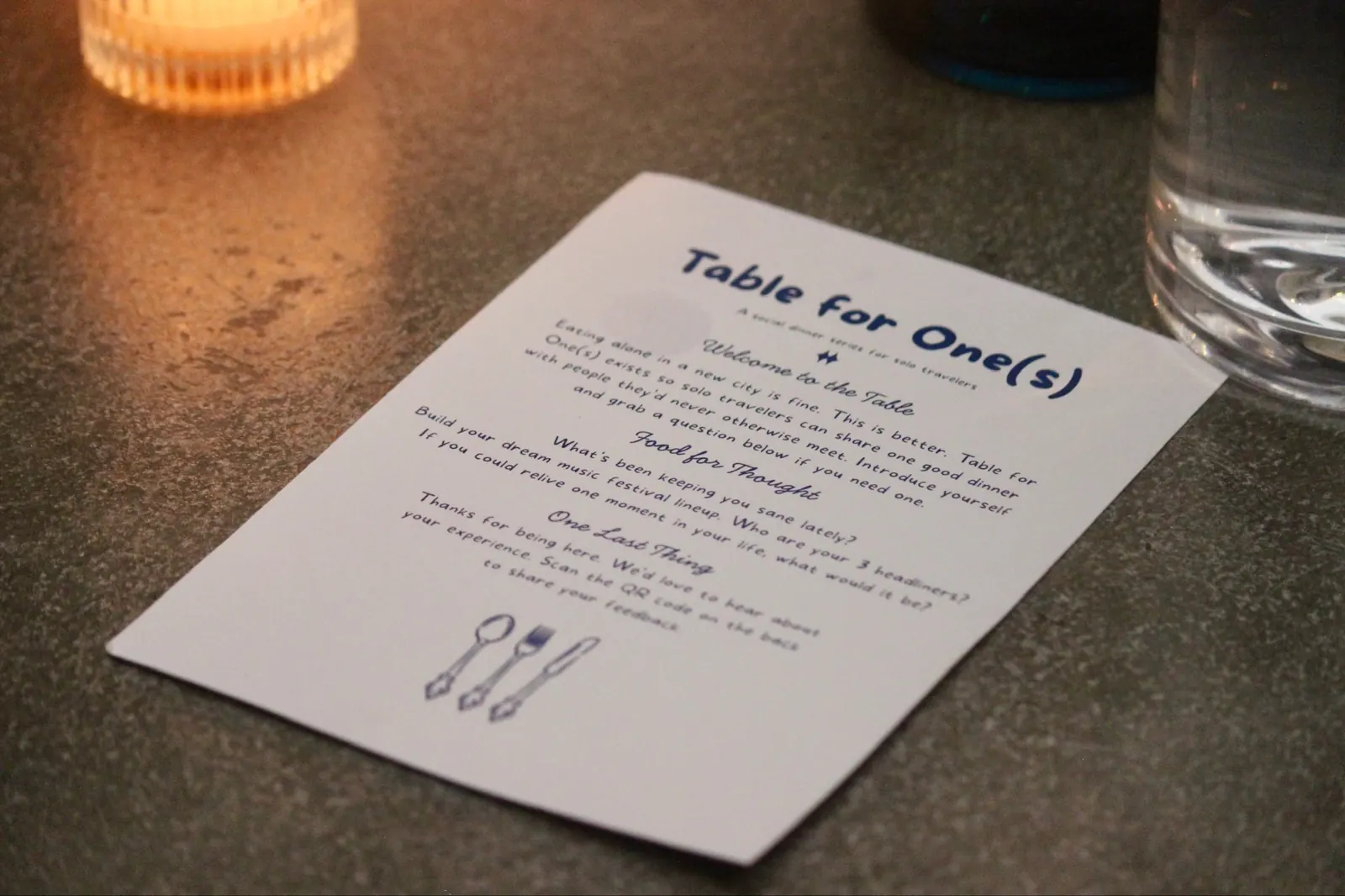 a table for one(s) menu card by candlelight