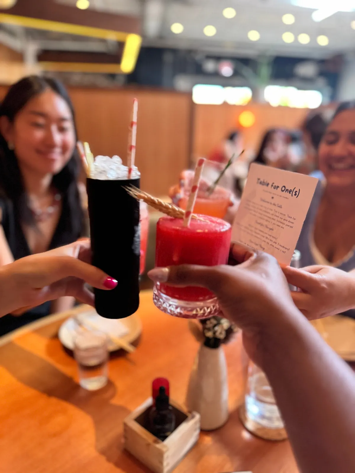 solo travelers toasting cocktails at a shared dinner